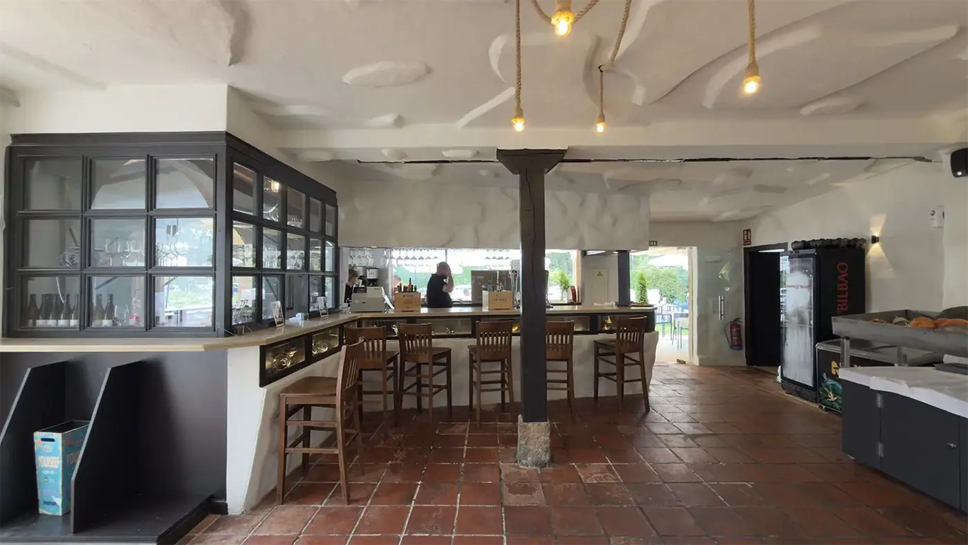 Barra del restaurante con lámparas de cuerda y suelo de barro